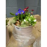 Pink metal pot containing assorted flower arrangement