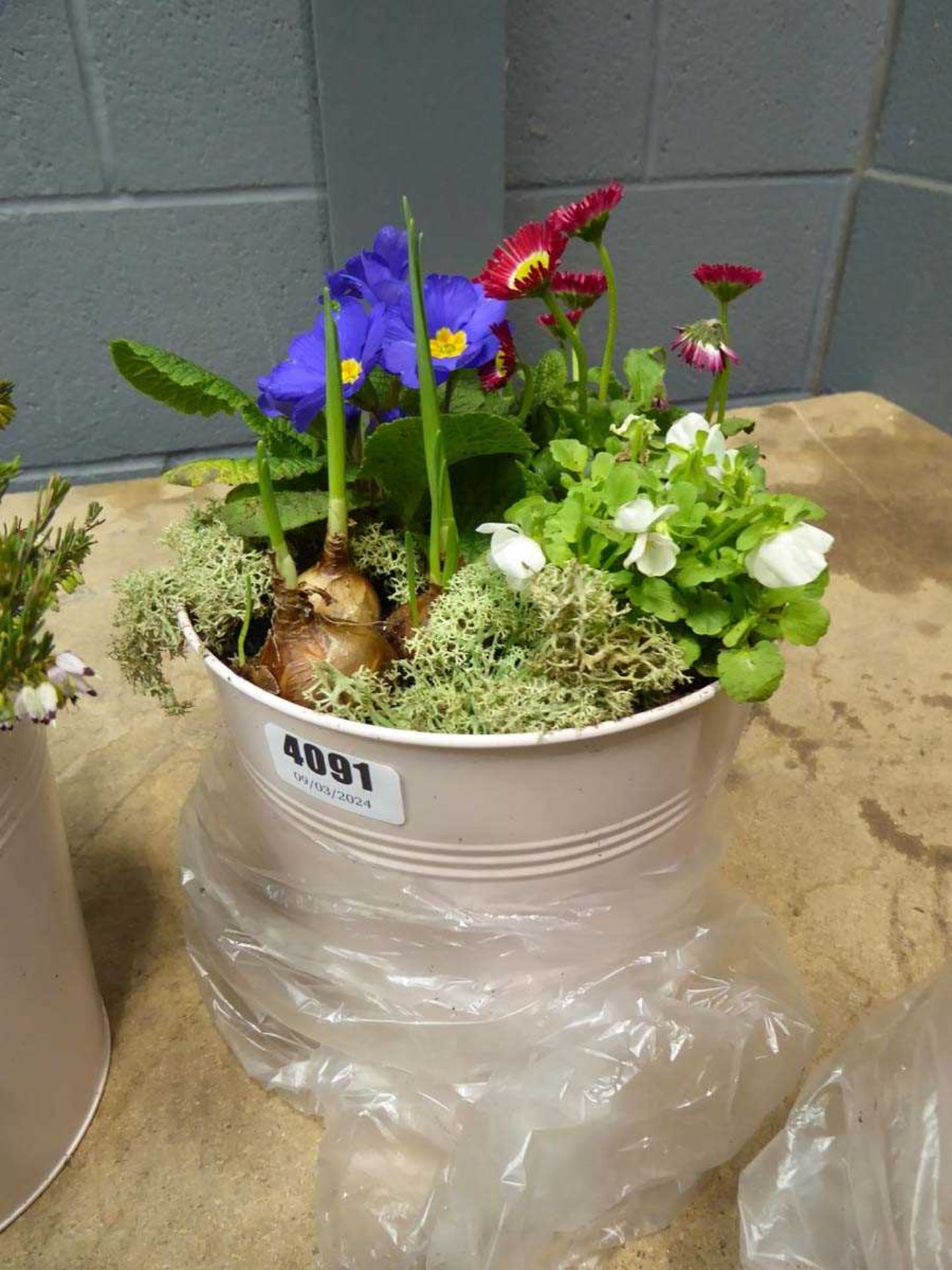 Pink metal pot containing assorted flower arrangement