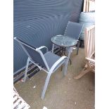 Small round glass topped table and grey mesh chairs