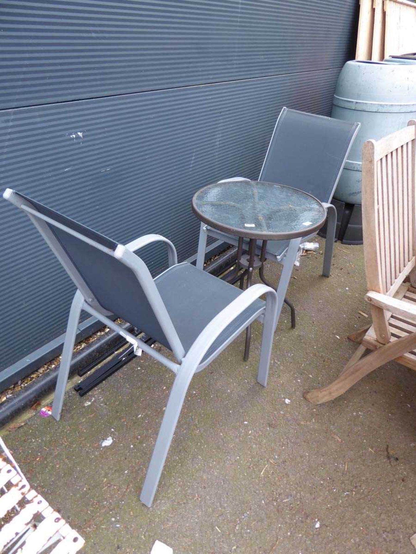 Small round glass topped table and grey mesh chairs