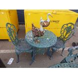 Small round metal garden table with two chairs and two metal ducks