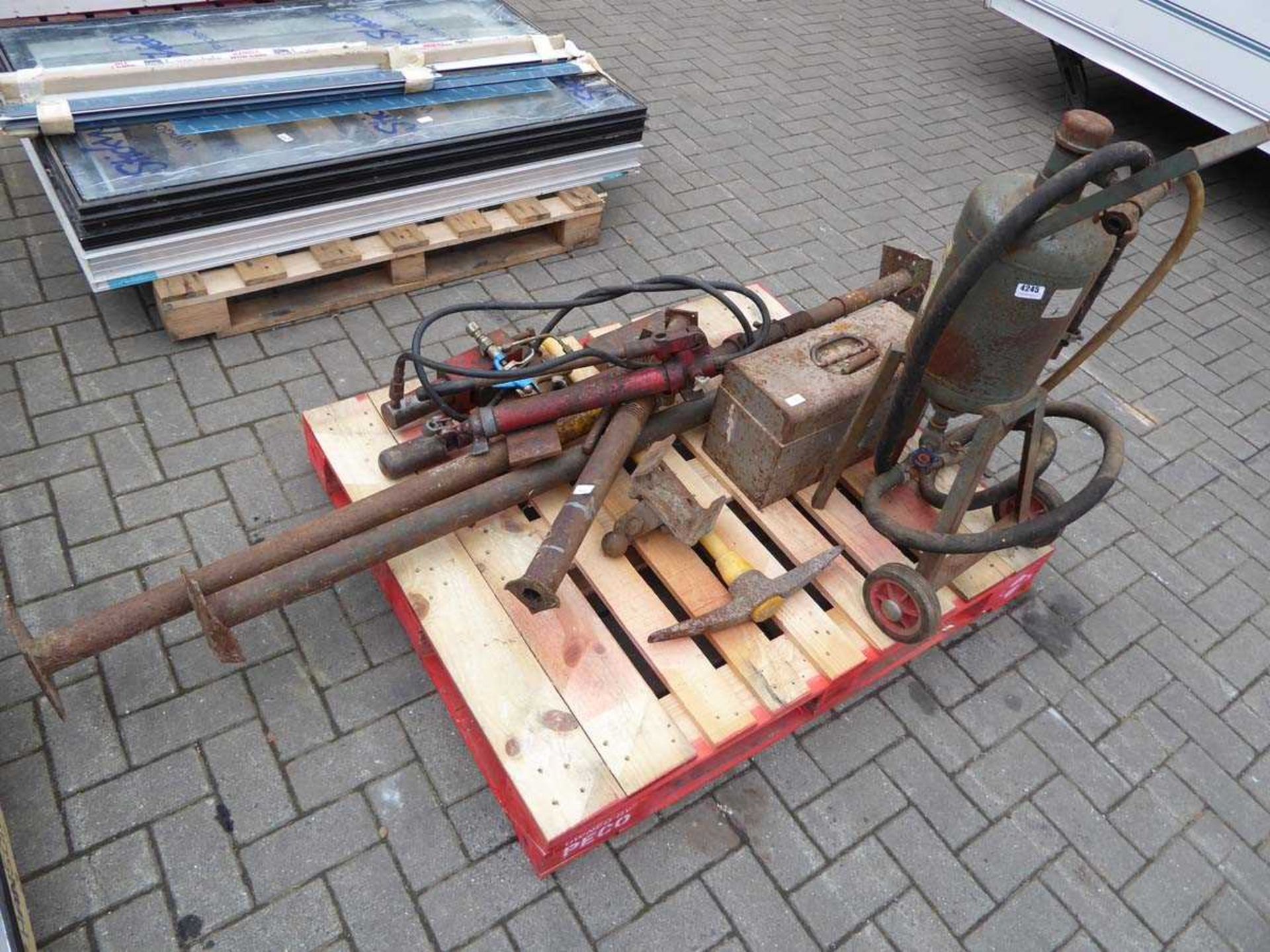 Pallet containing sand blasting pot, small acrow prop, body jack set, pickaxe etc.