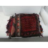 A group of three Central Asian saddle bags together with two similar woollen wall hangings (5)