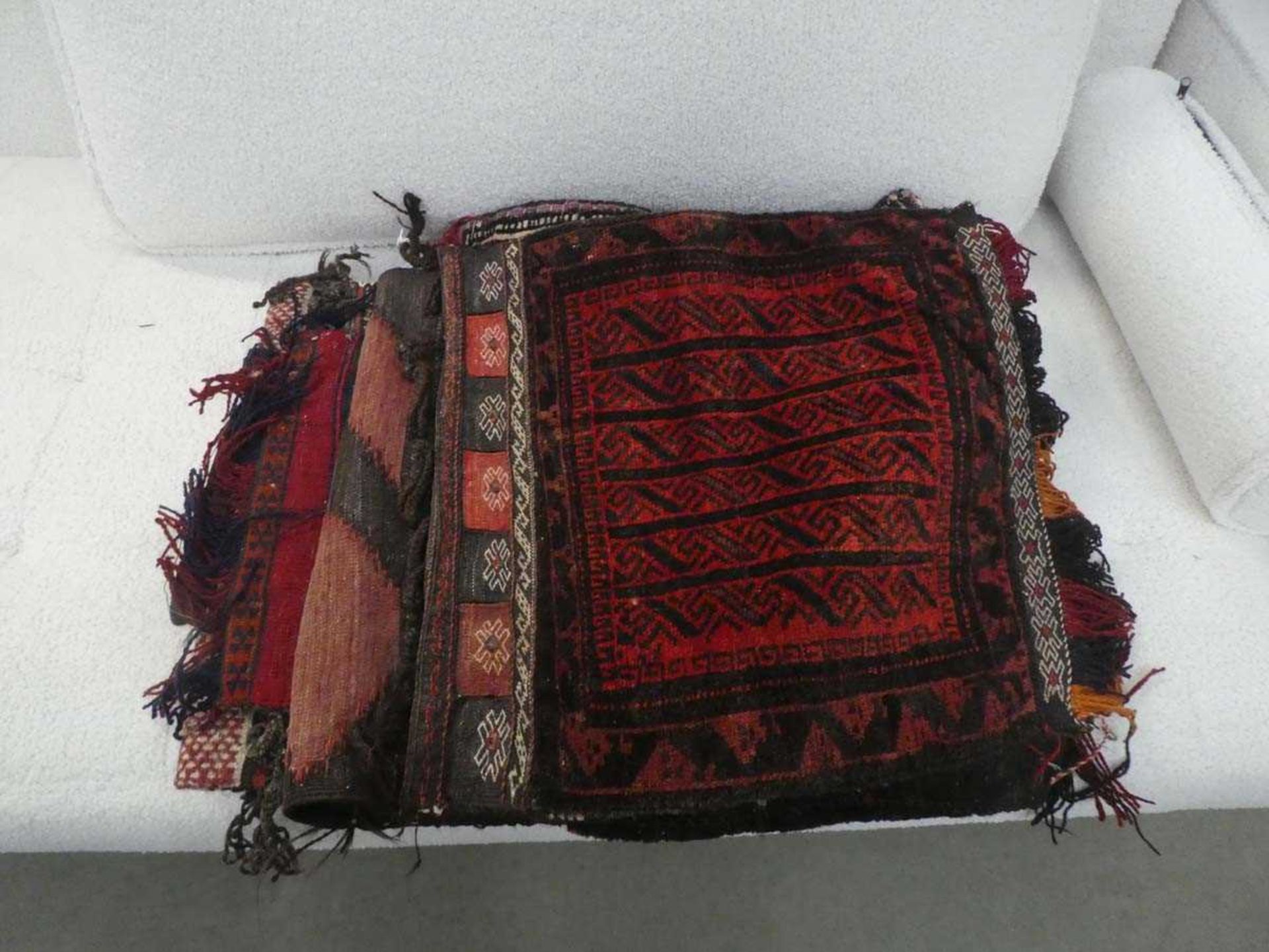 A group of three Central Asian saddle bags together with two similar woollen wall hangings (5)