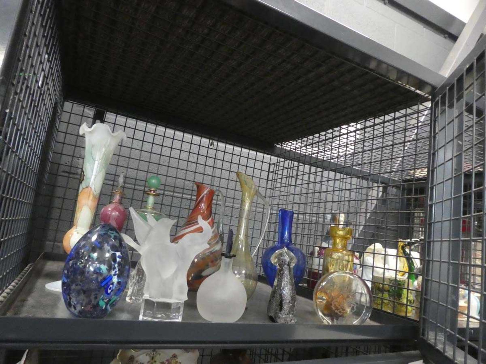 Cage containing glass jugs, ornamental figures, and paperweighs and scent bottles