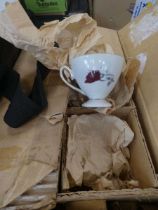 Box containing rose patterned crockery
