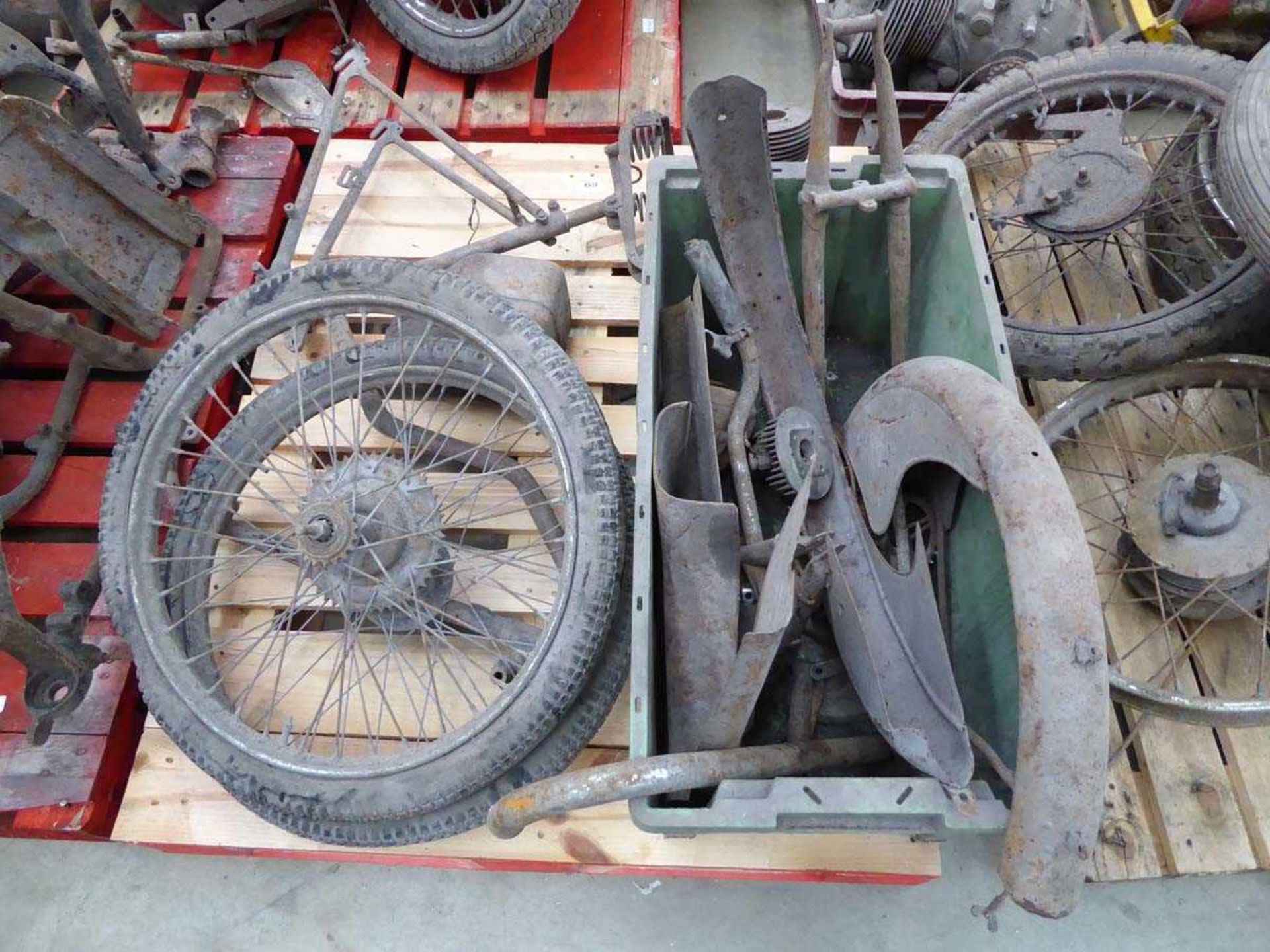 Pallet of vintage motorcycle parts including frame, wheels, mudguards, etc