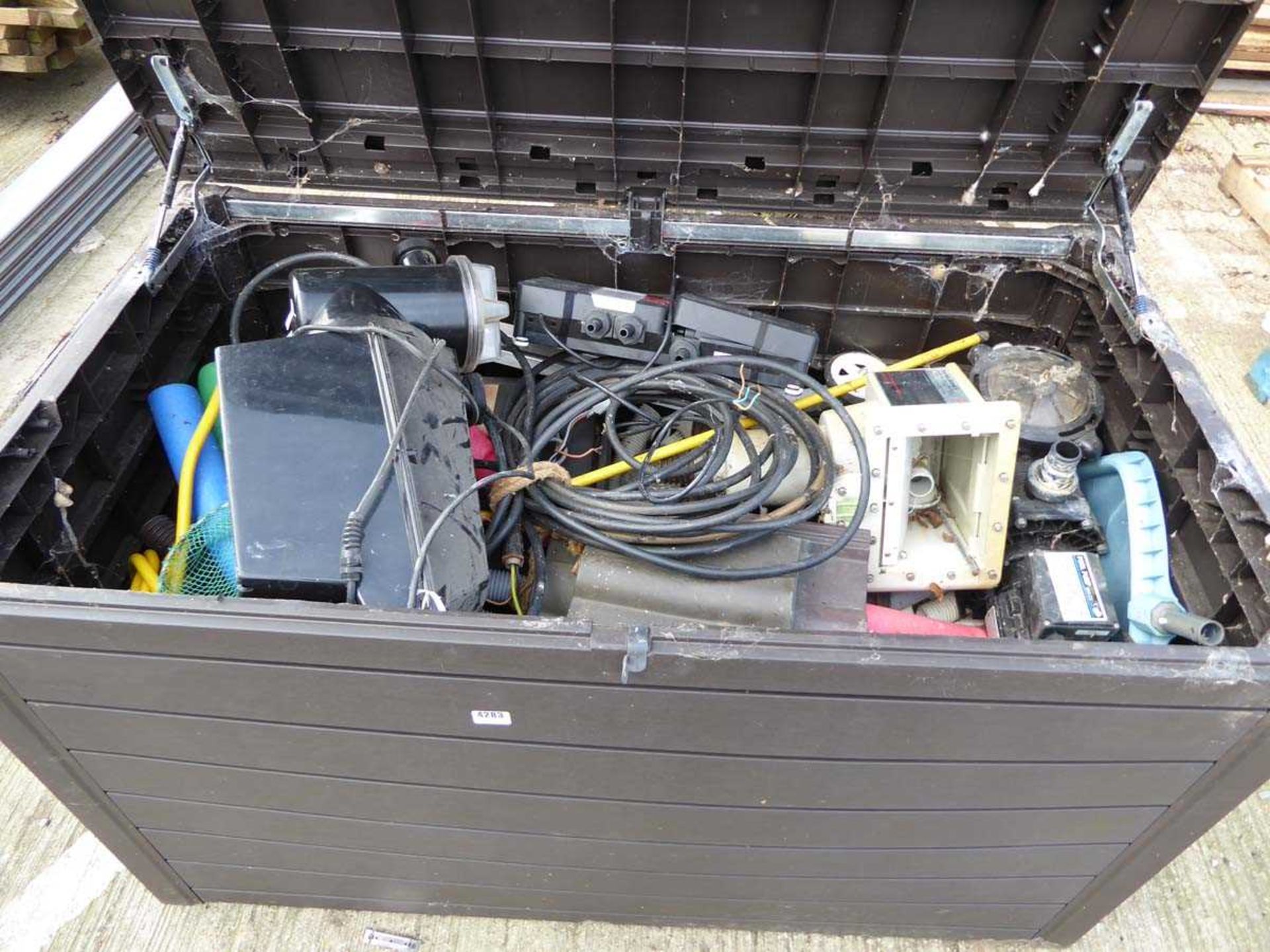 Large plastic box containing various items including pool pumps, pond pumps, filters, nets, etc