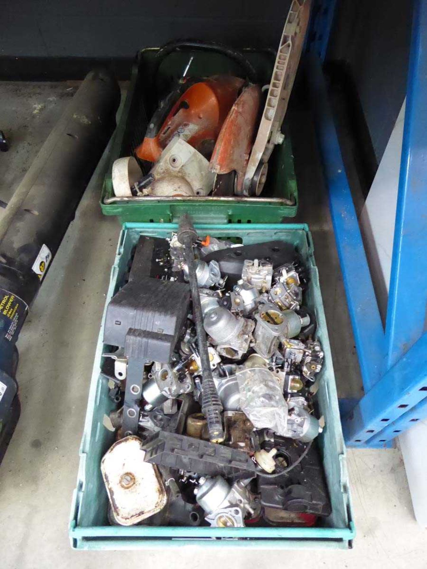 Two boxes containing disc cutter and petrol engine small car parts, including carburettors, covers