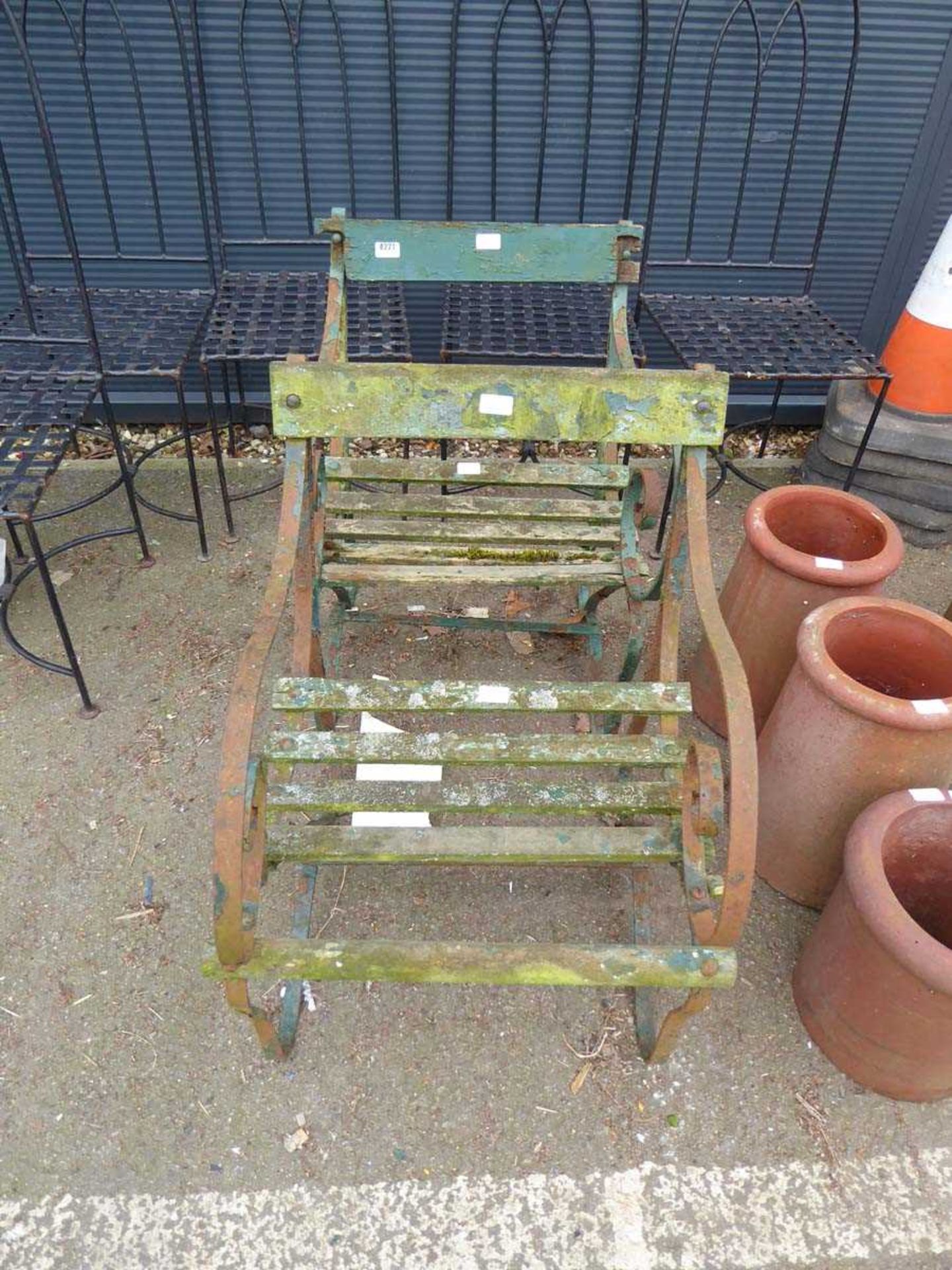 Pair of slatted wood wrought iron ended garden seats in green