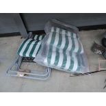 Two white and green upholstered garden sun loungers