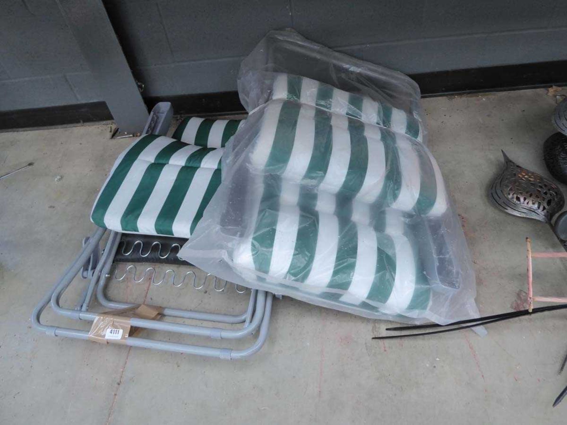 Two white and green upholstered garden sun loungers