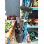 Plastic bin containing garden tools to include brushes, spades, and trellis