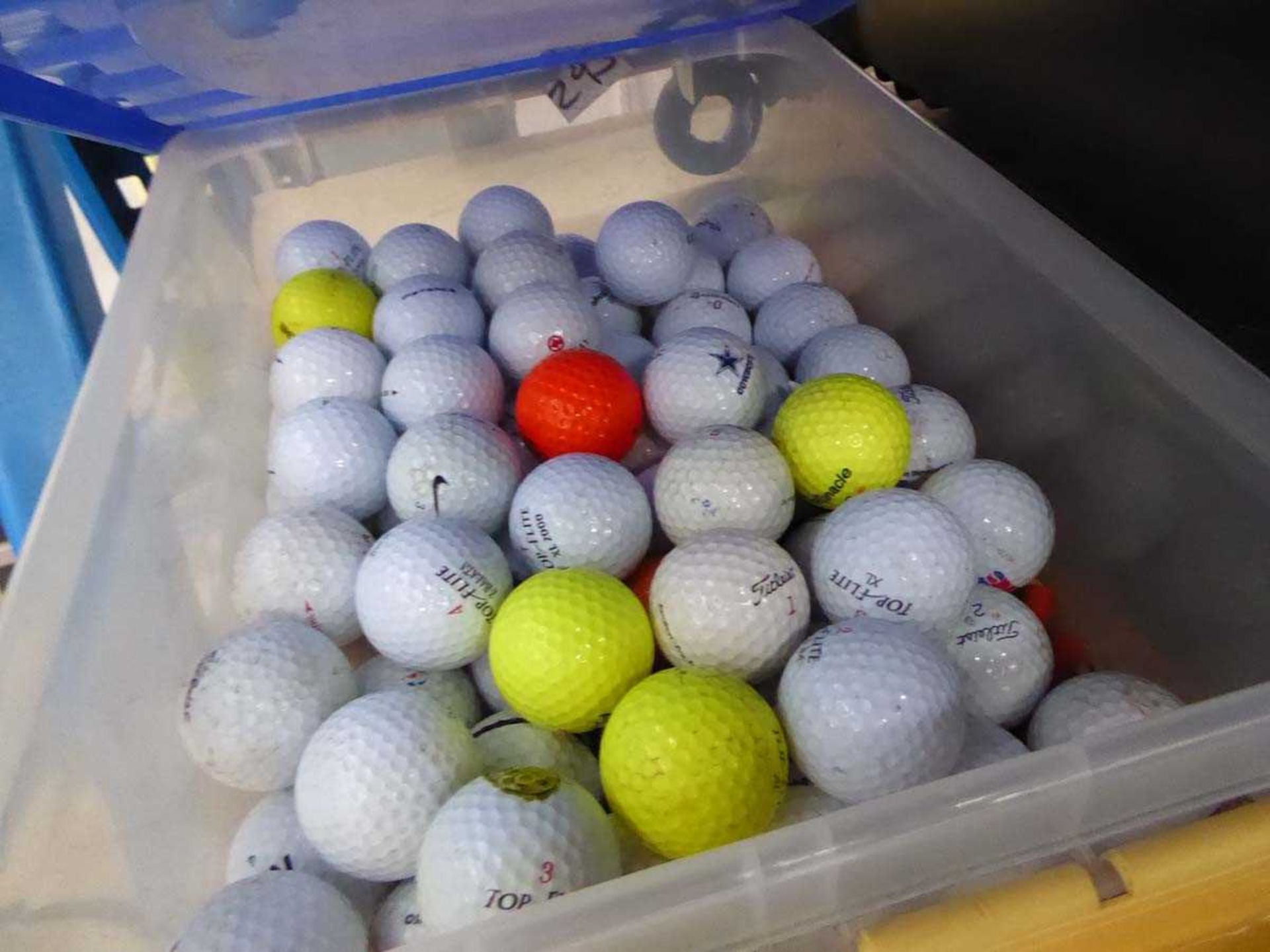 Plastic crate of assorted golf balls