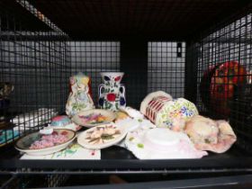 Cage containing floral pattern wall plaque, jugs and ornamental hats