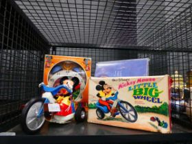 Cage containing Mickey Mouse figure on trike, plus clock and Disney Treasures audiobooks