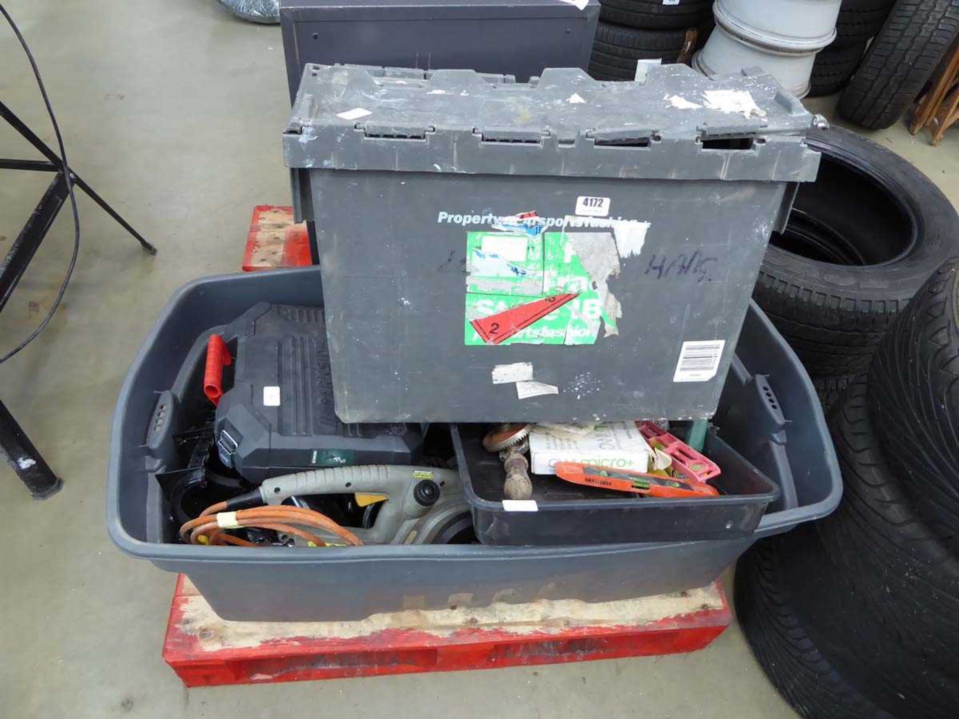 Two large boxes containing various tools, including chainsaw, drills, plumbing fittings, drainpipe