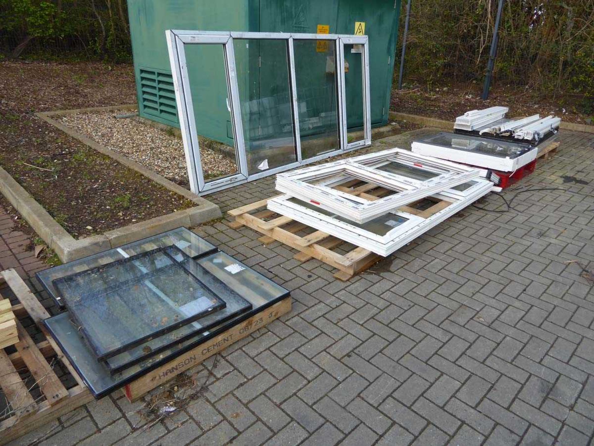 Four pallets containing various windows, glazed and unglazed, including roof window