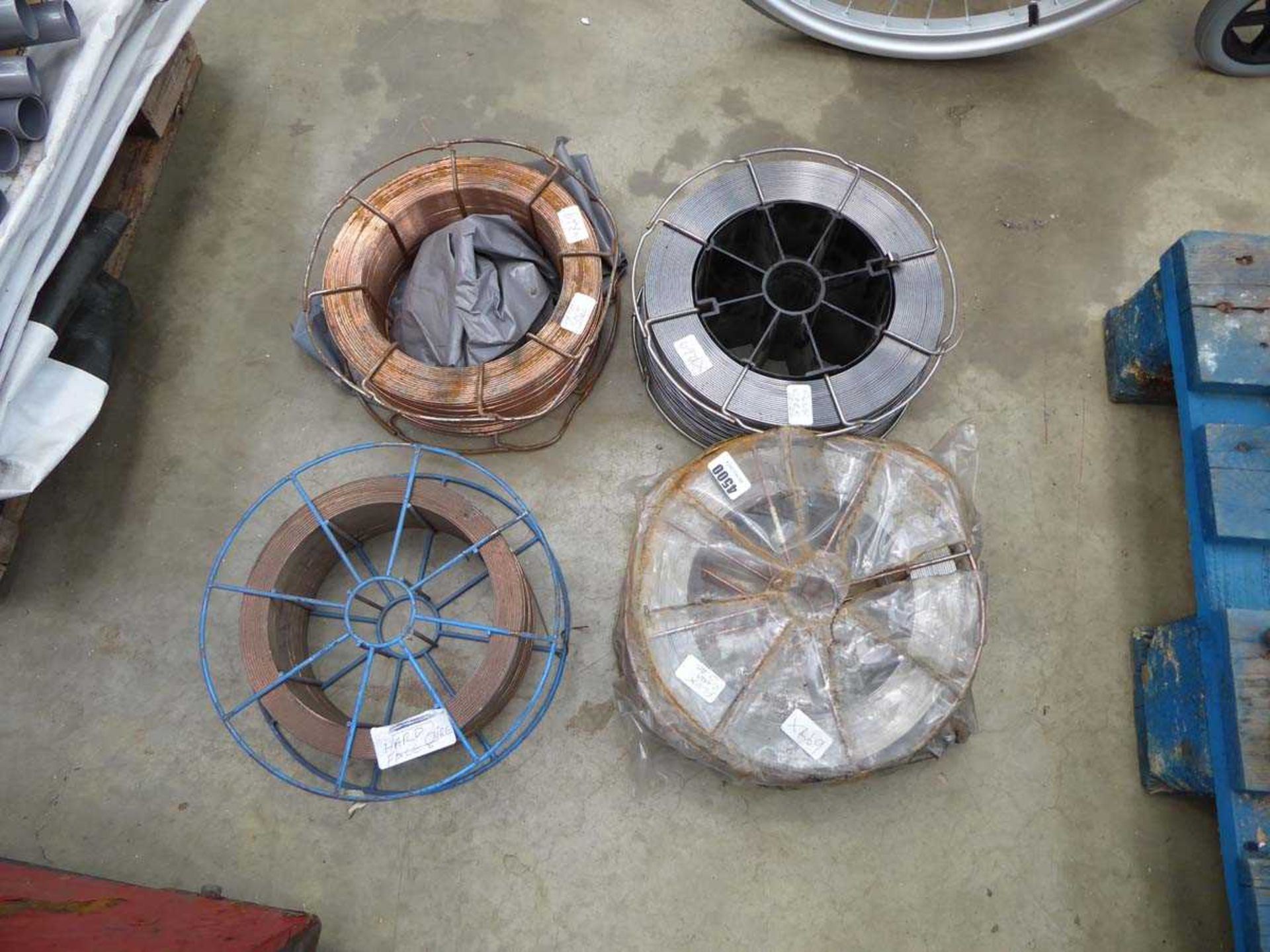 Four large rolls of welding wire to include flux core wire and hard face wire