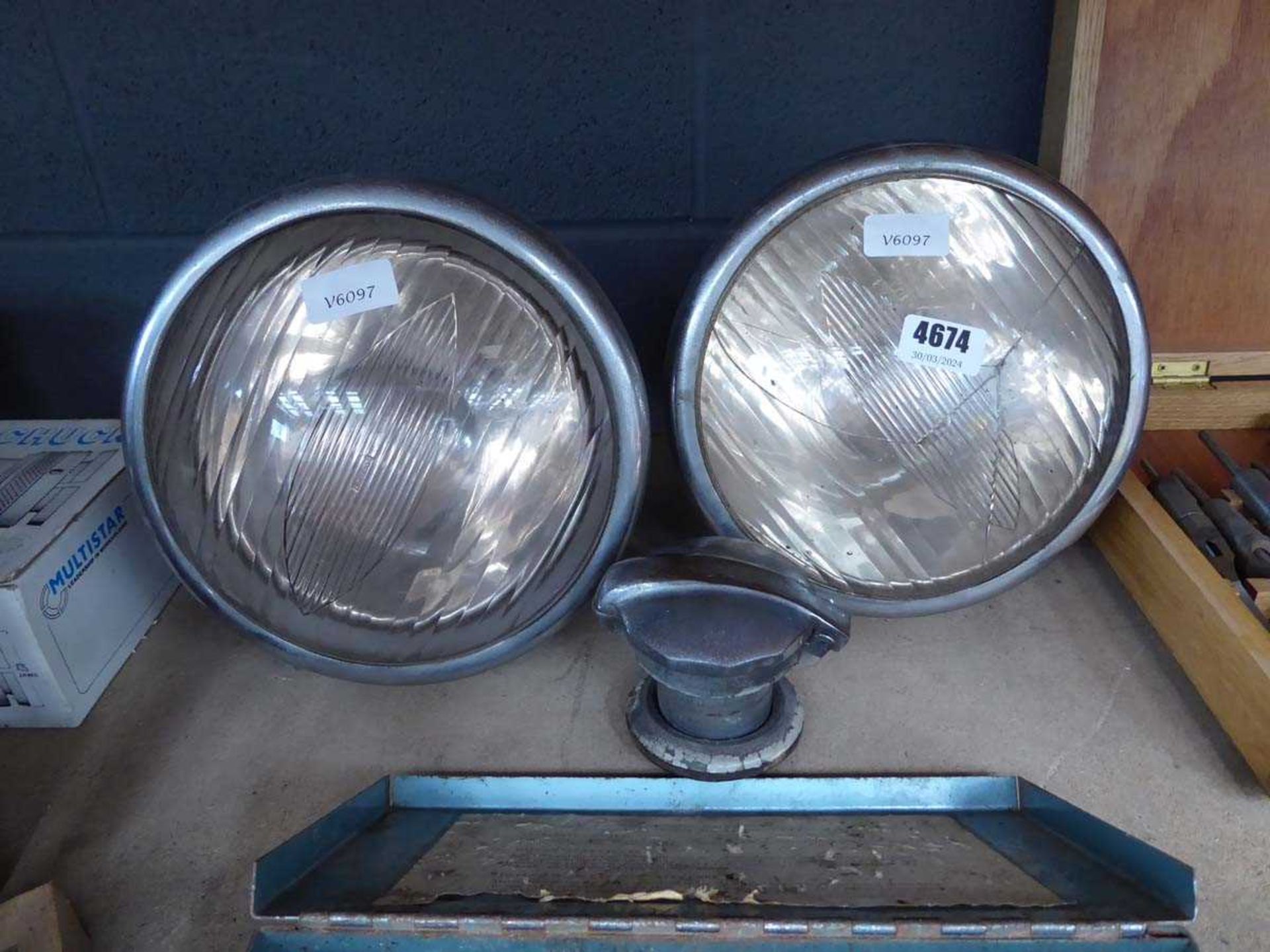 2 vintage car head lights and a fuel cap