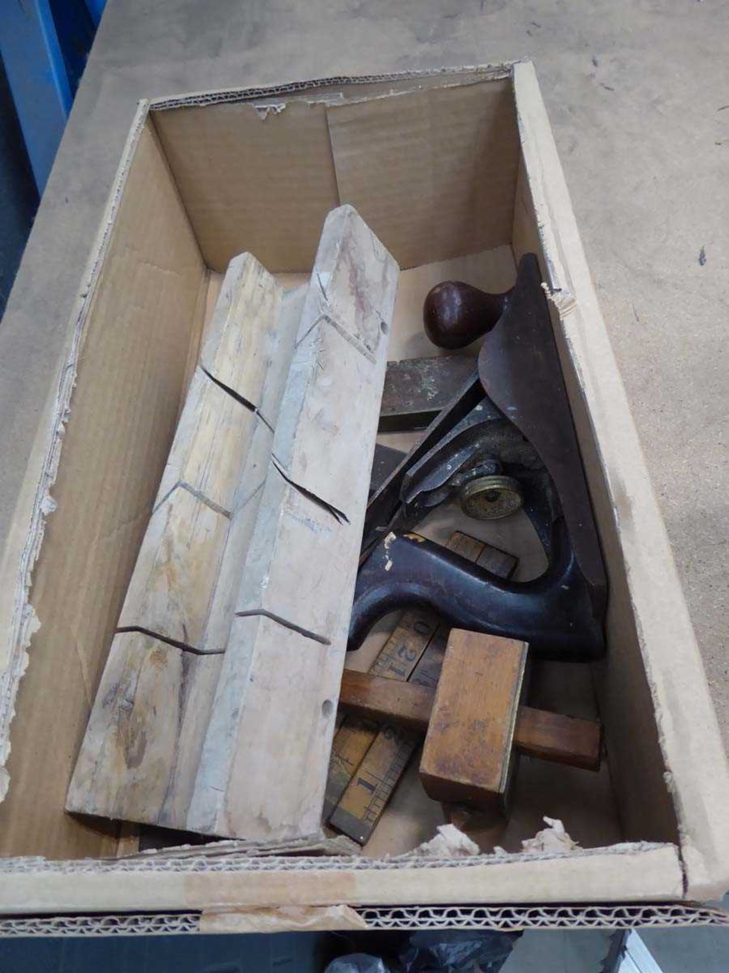 Box containing small hand plane, measure, wooden angle block, etc