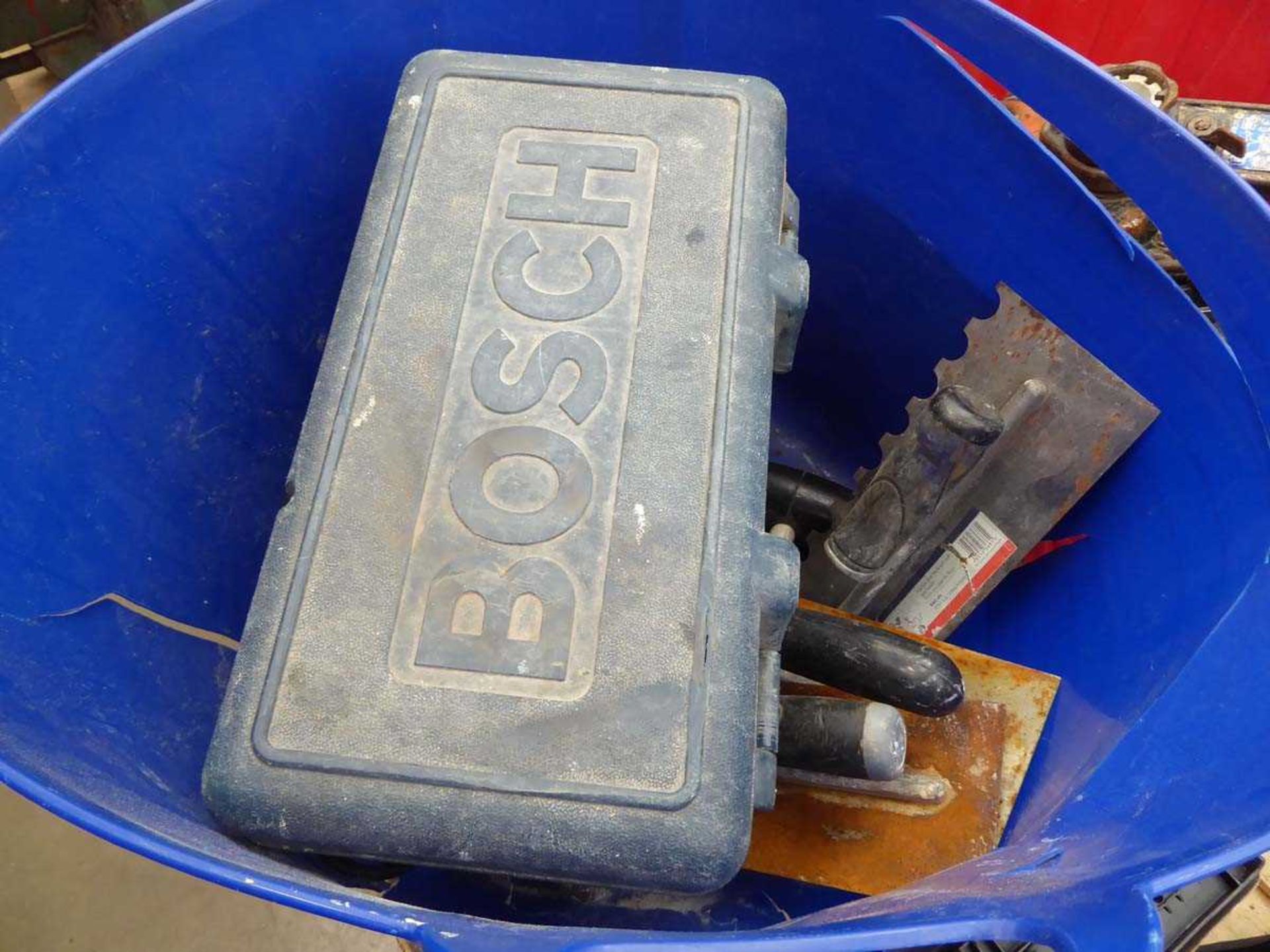 Red bucket containing Bosch 110V angle grinder, plaster tools and hammer