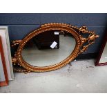 Oval mirror in decorative urn and swag patterned frame
