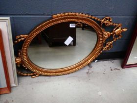 Oval mirror in decorative urn and swag patterned frame