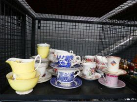 Cage of blue and white and rose patterned cups and saucers