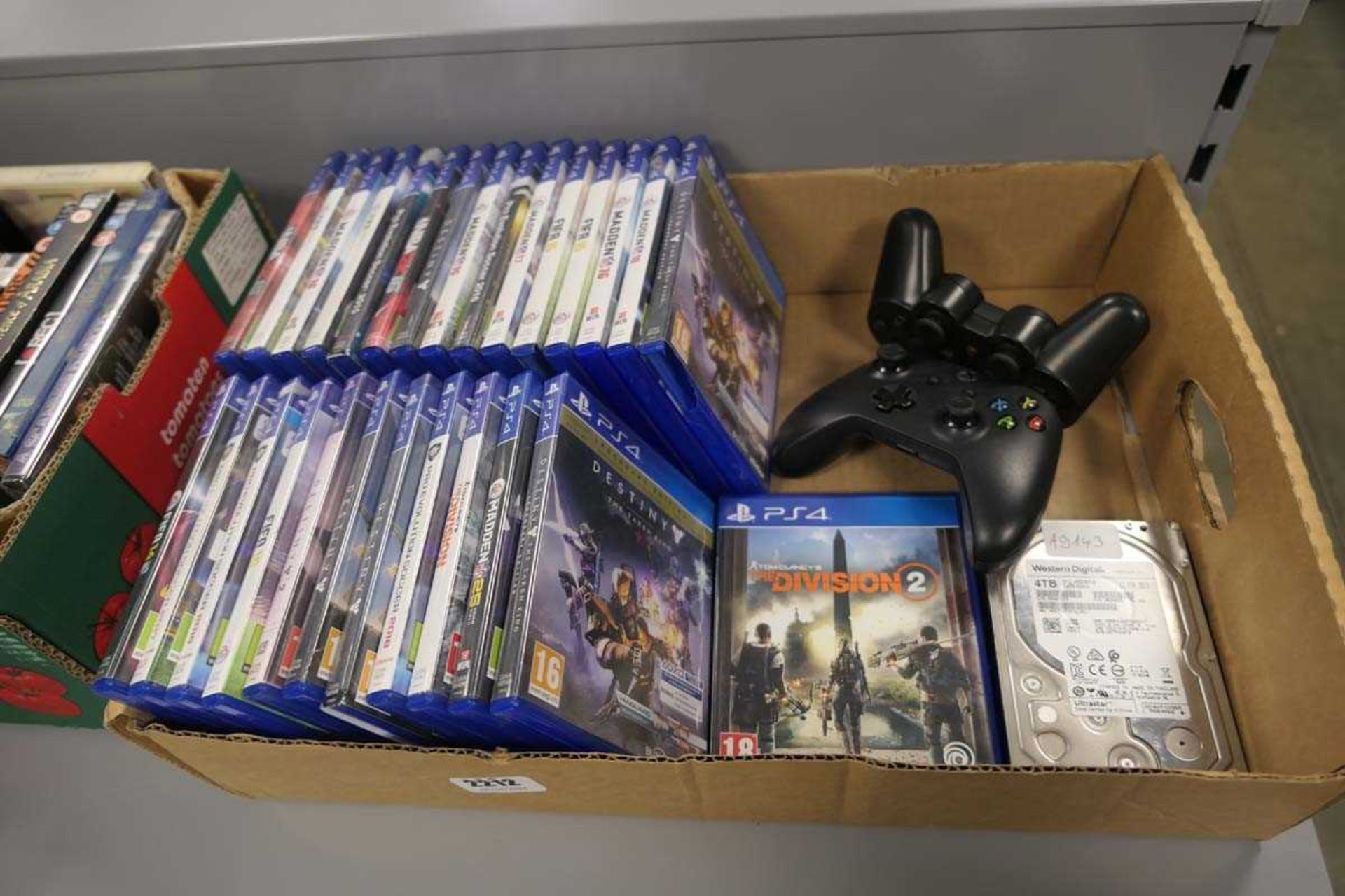 Box containing PS4 games, Western Digital 4TB hard drive, and 2 controllers (Xbox and PS)