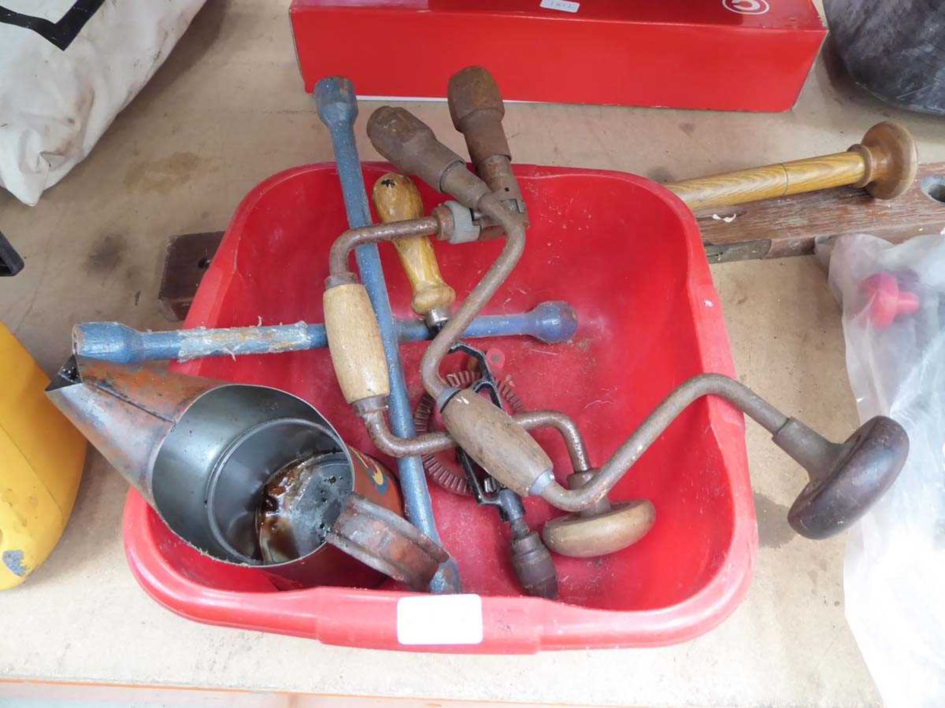 Small washing up bowl containing Esso oil tin, 2 hand drills, wheel brace and small spirit level