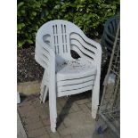 4 white plastic stacking chairs