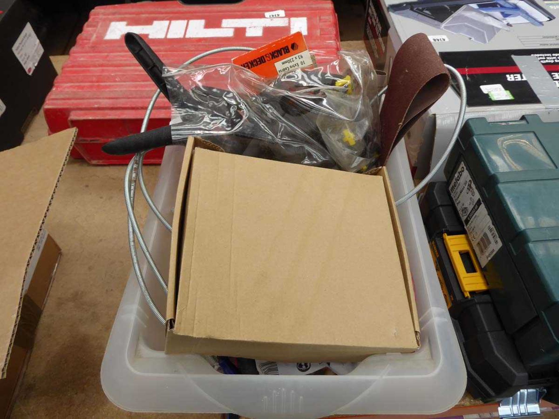 Plastic box of drain snake, sanding belts and various other tools