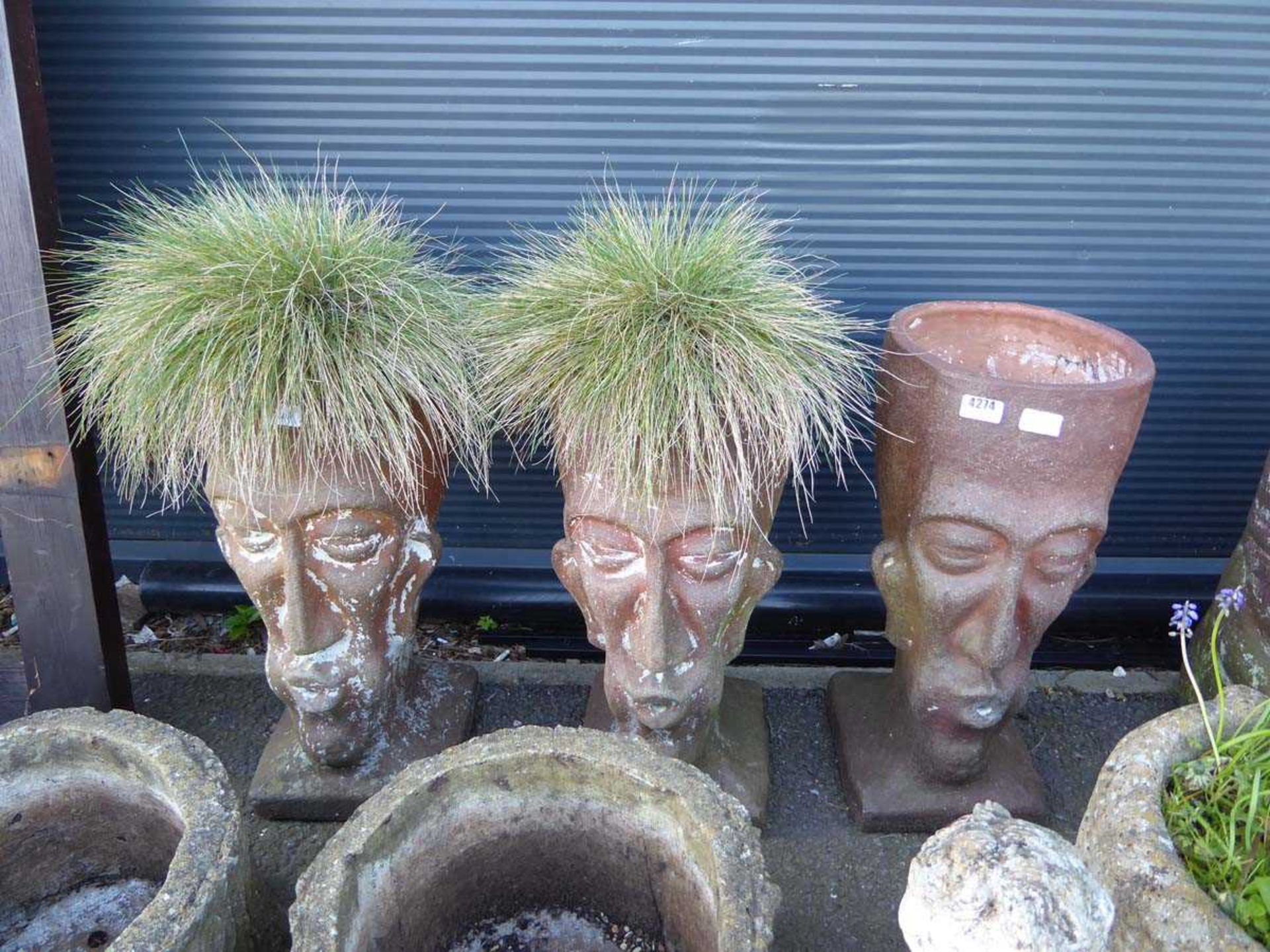 3 terracotta planters in the form of heads - 2 with grass