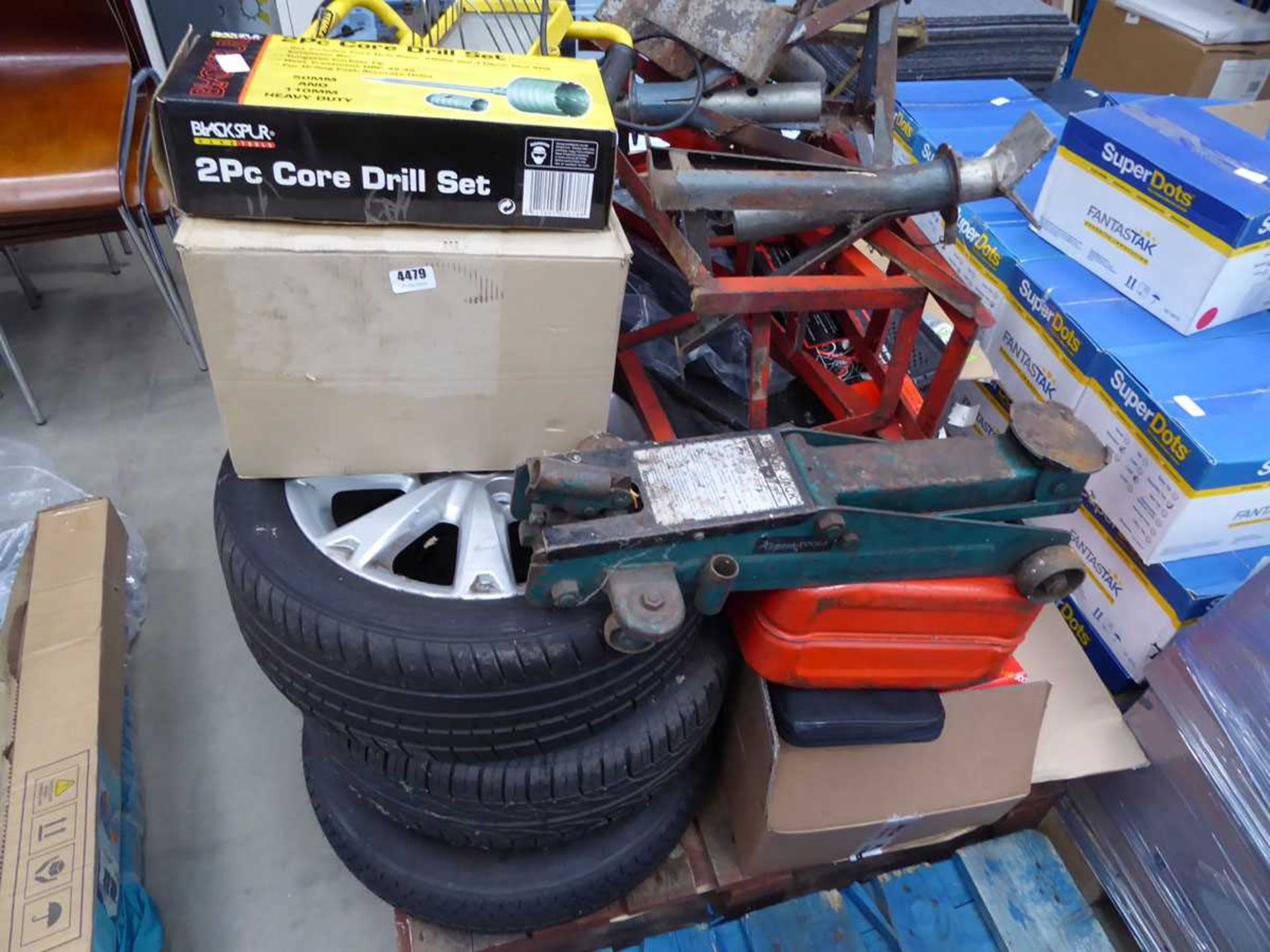 Pallet of assorted items including alloy wheel, tyres, trolley jack, axle stands, lights, etc