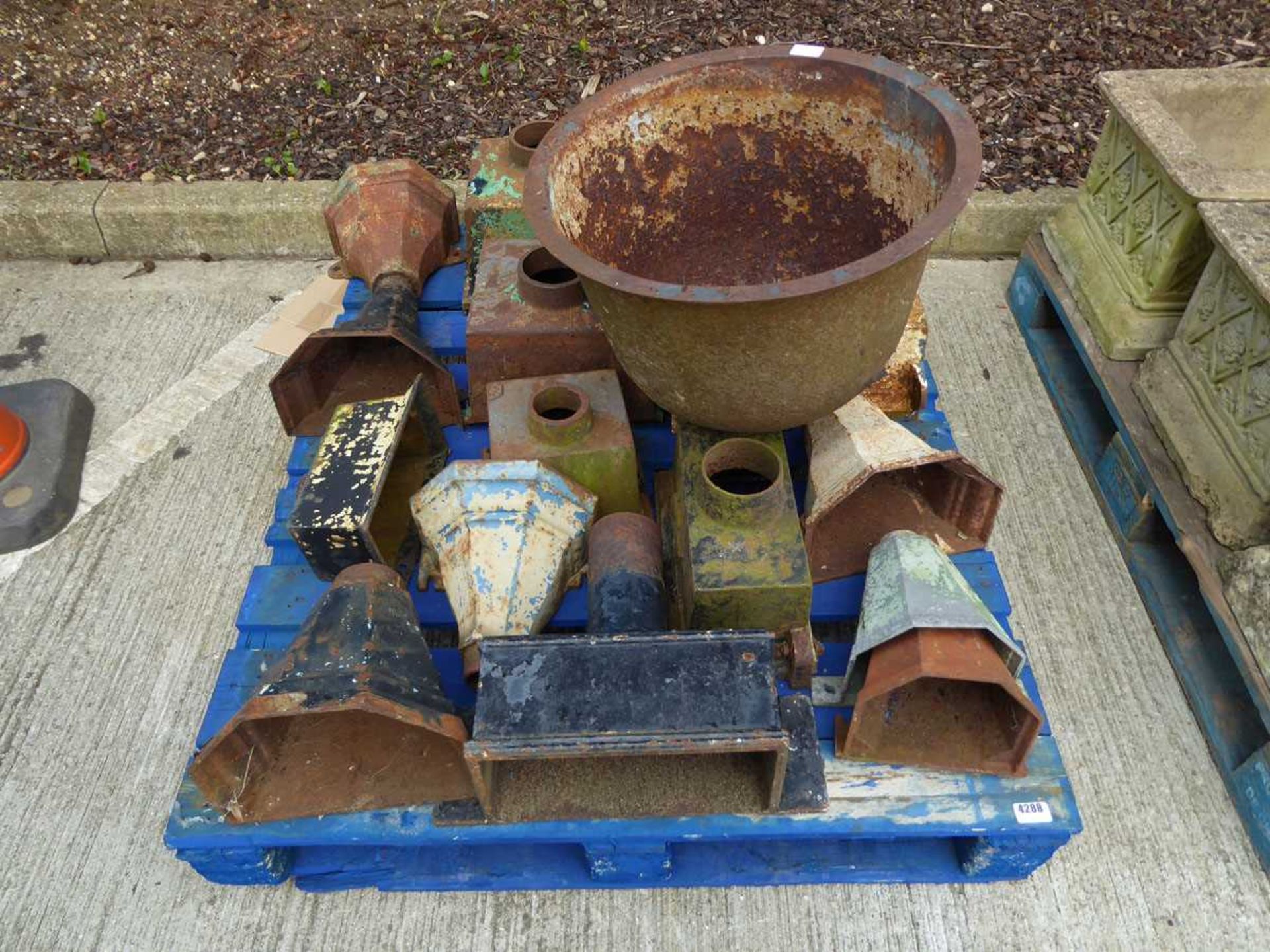 Pallet of cast iron rainwater hoppers and a vintage boiler