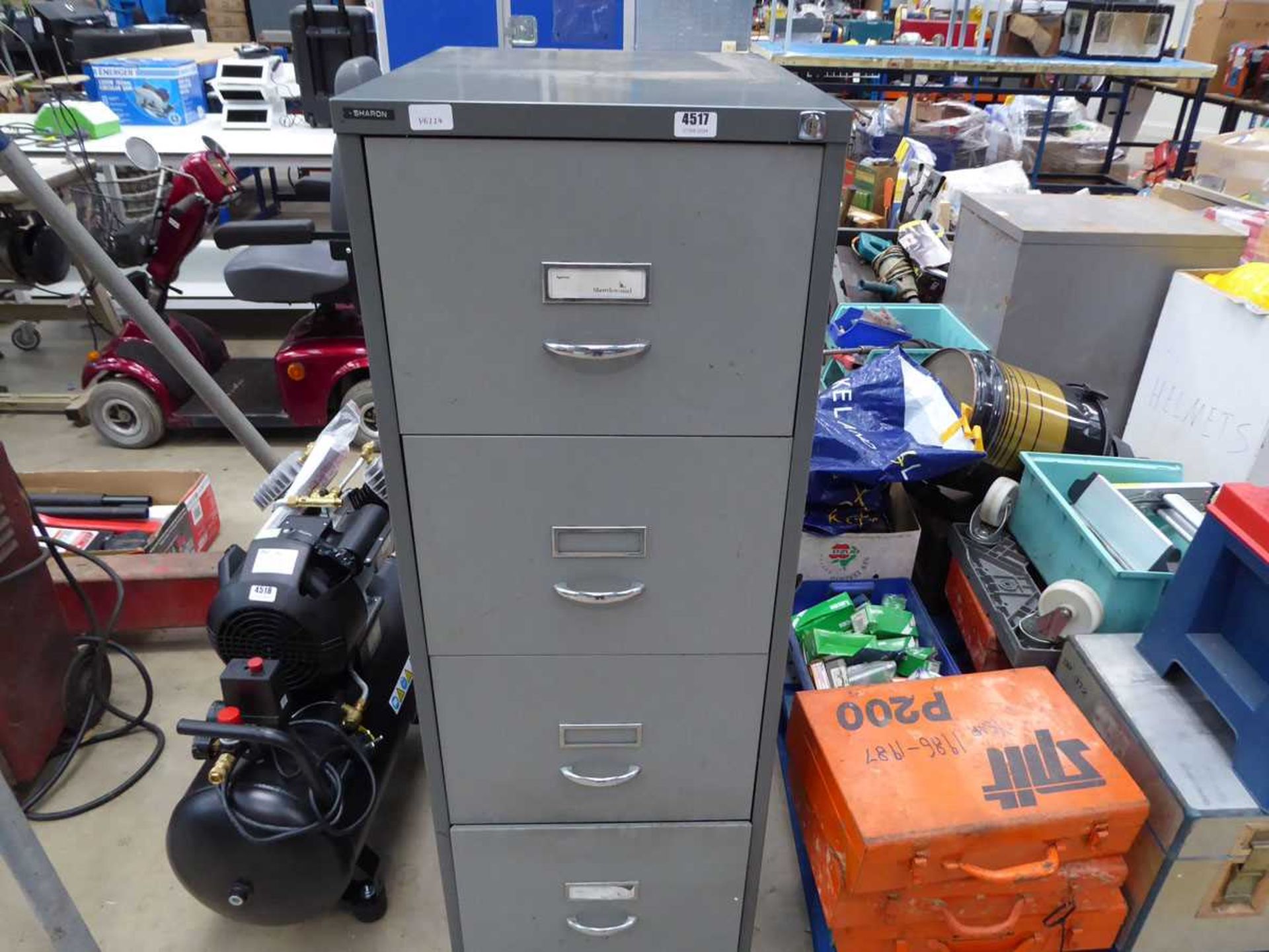 Grey metal filing cabinet containing gloves and tools including jigsaw, timing lights, punch sets,