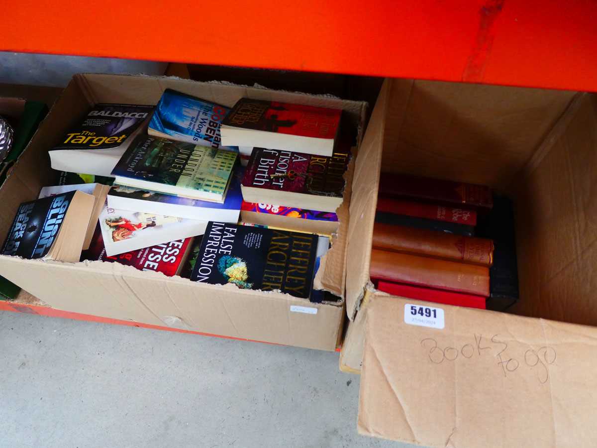 2 boxes containing paperback novels, medical guides, and reference books