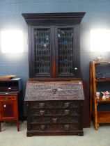 Heavily carved oak bureau bookcase with glazed and leaded door panels Approx. dimensions: depth 20