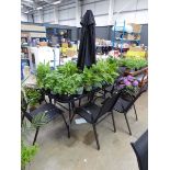 Large rectangular glass topped metal framed table with six chairs and a black parasol