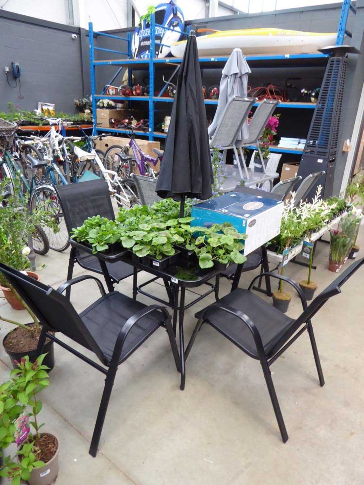 Square glass topped garden table with 4 matching chairs and parasol