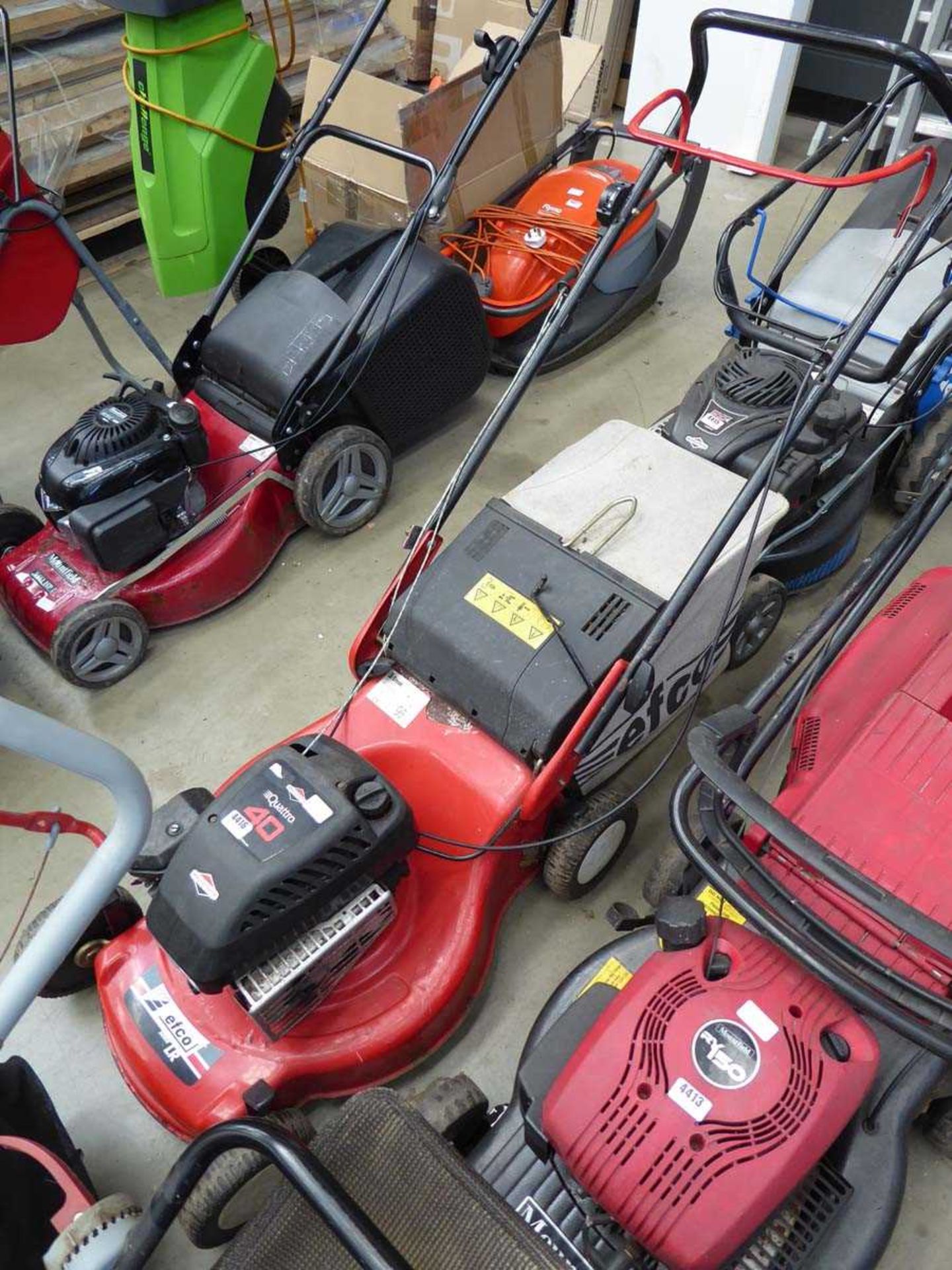 Red petrol powered rotary mower with grass box