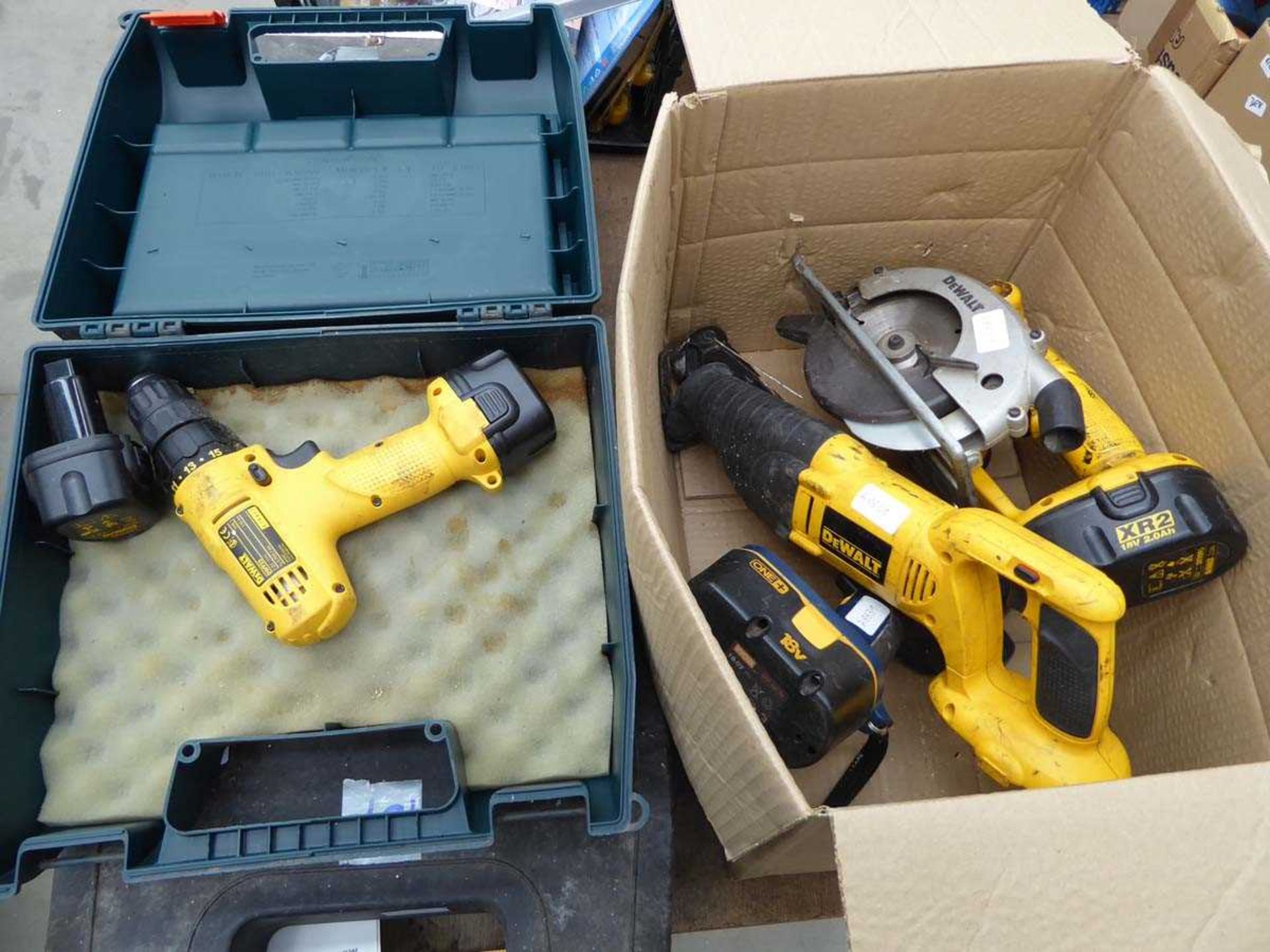 Small DeWalt battery drill and box containing used DeWalt tools