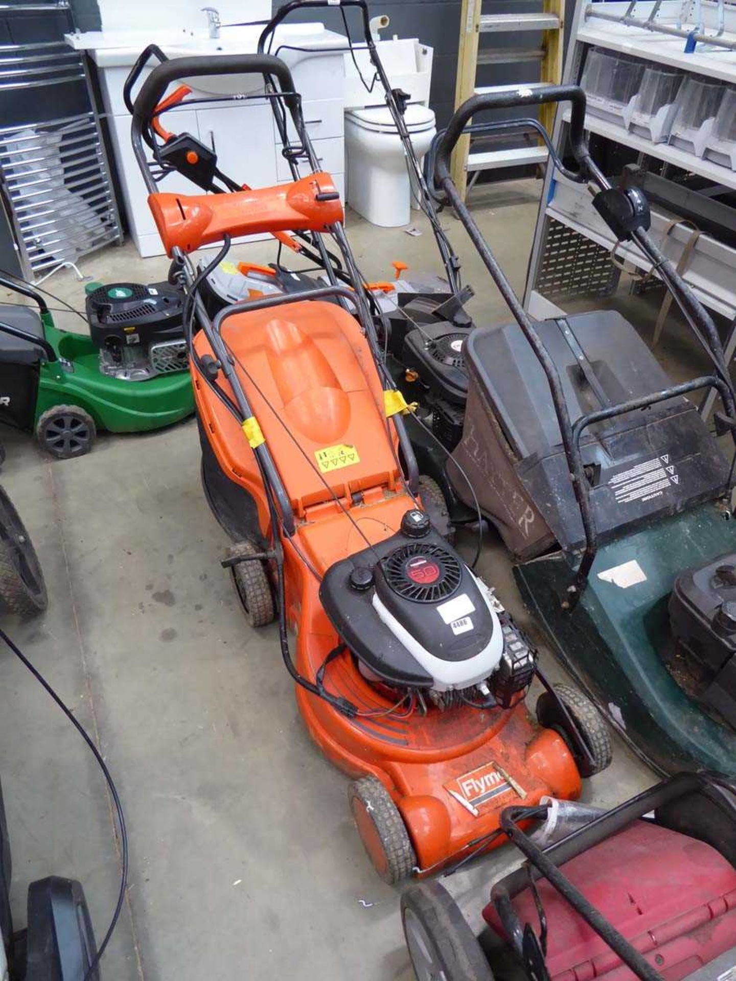 Flymo orange petrol powered rotary mower with grass box