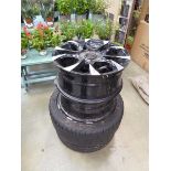 Four black and silver alloy wheels and two tyres