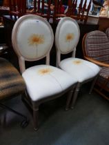 Pair of cream painted and floral patterned dining chairs