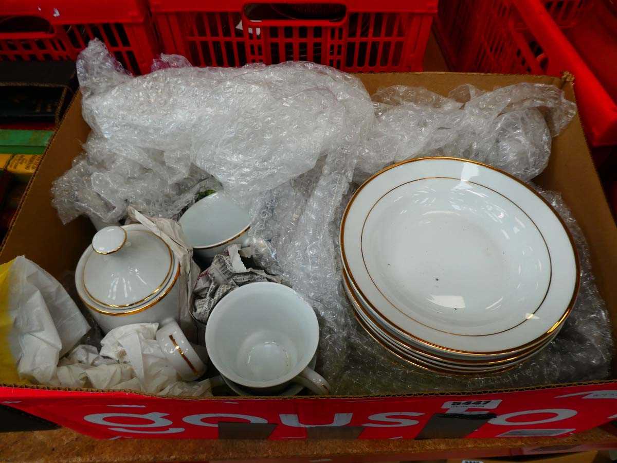 Box containing gold rimmed tableware