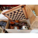 Two boxes containing mantel clocks, chess board, African mask, and camera