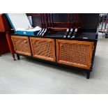 Low slung entertainment unit with three wicker panelled doors under