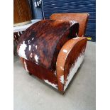 Cowhide upholstered armchair with matching footstool Some scuffing to legs